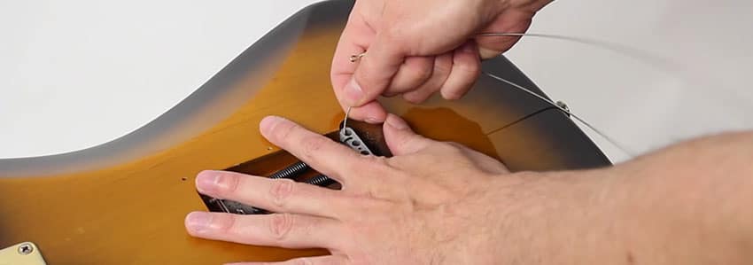 Retira la tapa trasera para cambiar las cuerdas de la guitarra eléctrica