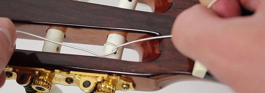 Hacer nudo de la cuerda de nylon para una guitarra clásica